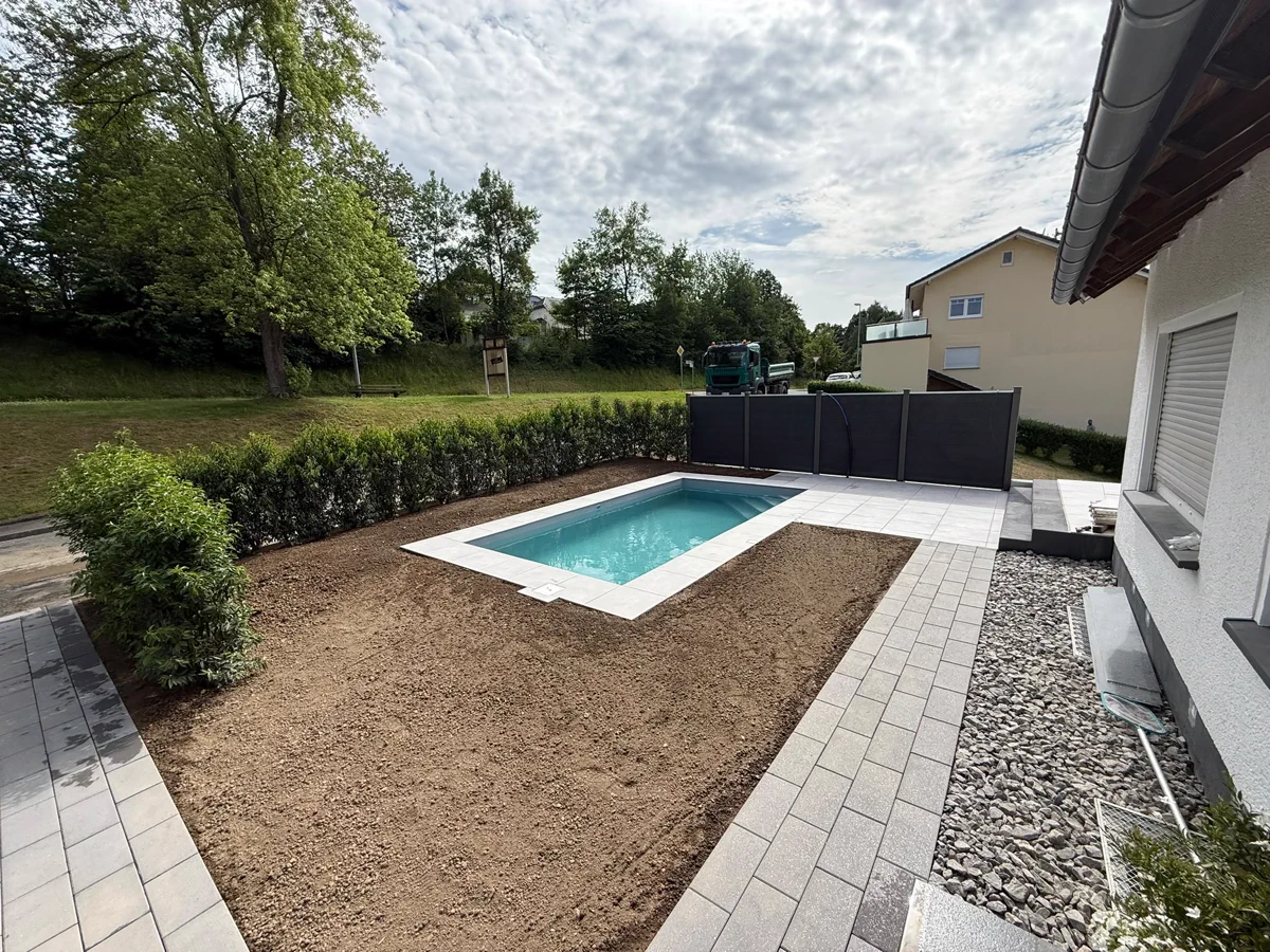 Blick aus dem Garten auf Becken, Terrasse und Rasenfläche