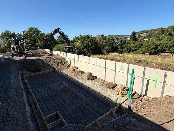 Bewehrungsmatten und Holzschalung für eine Betonfläche zwischen zwei L-Steinreihen