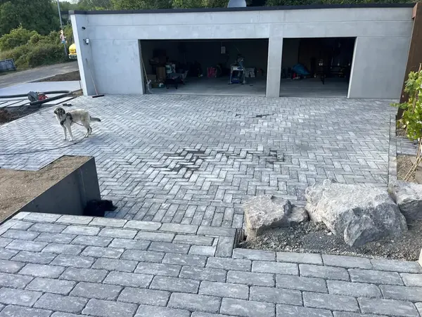 Fertige Pflasterfläche in Antikoptik vor einer weißen Doppelgarage